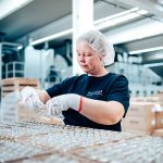 Mitarbeiterin kontrolliert die Qualität des Druckes