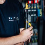 Nahaufnahme eines Elektronikers, der ein Messgerät hält