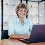 lohn-und-gehaltsbuchhaltung-2 Büromitarbeiterin an einem Konferenztisch lächelt in die Kamera